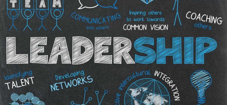 Notes on a blackboard the word "leadership" is highlighted in the center; other terms on the blackboard include: "coaching others", "identifying talent" or "building consensus" some of those terms are held by stick figures or accompanied by symbols like light bulbs or a globe
